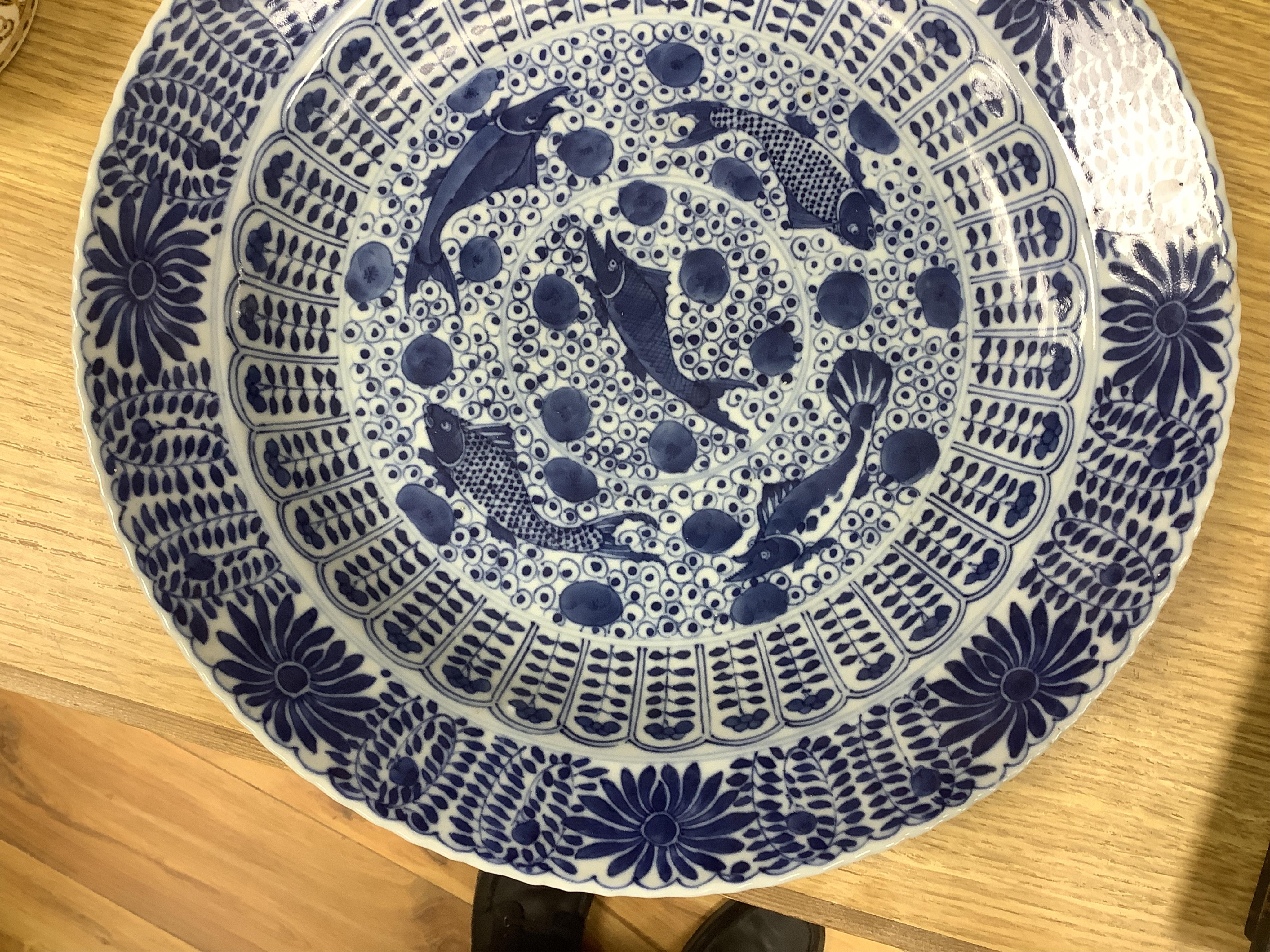 A Chinese blue and white 'fish' dish, Kangxi mark but c.1900, 33cm diameter. Condition - slight chipping to rim